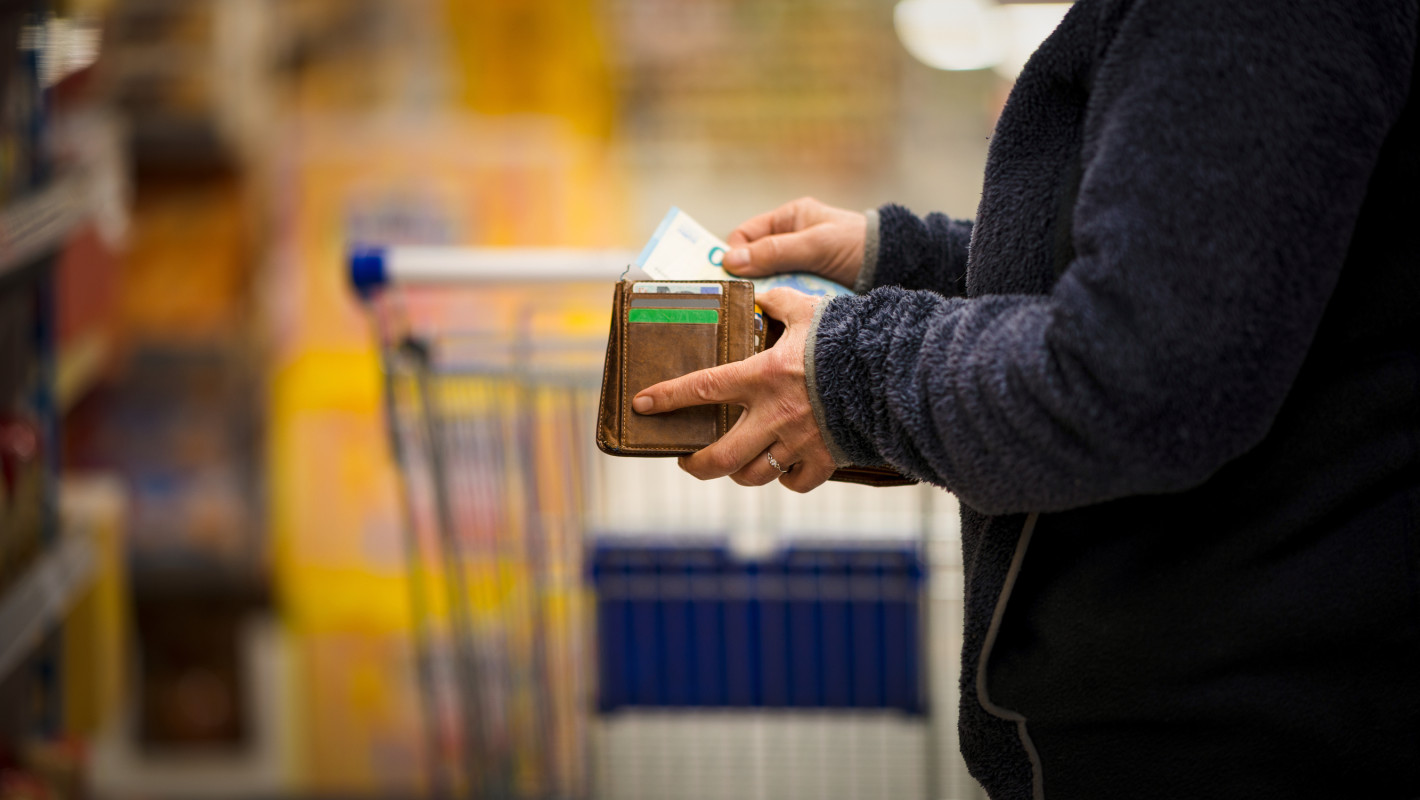 Mann der Geld aus seinem Portemonnaie nimmt